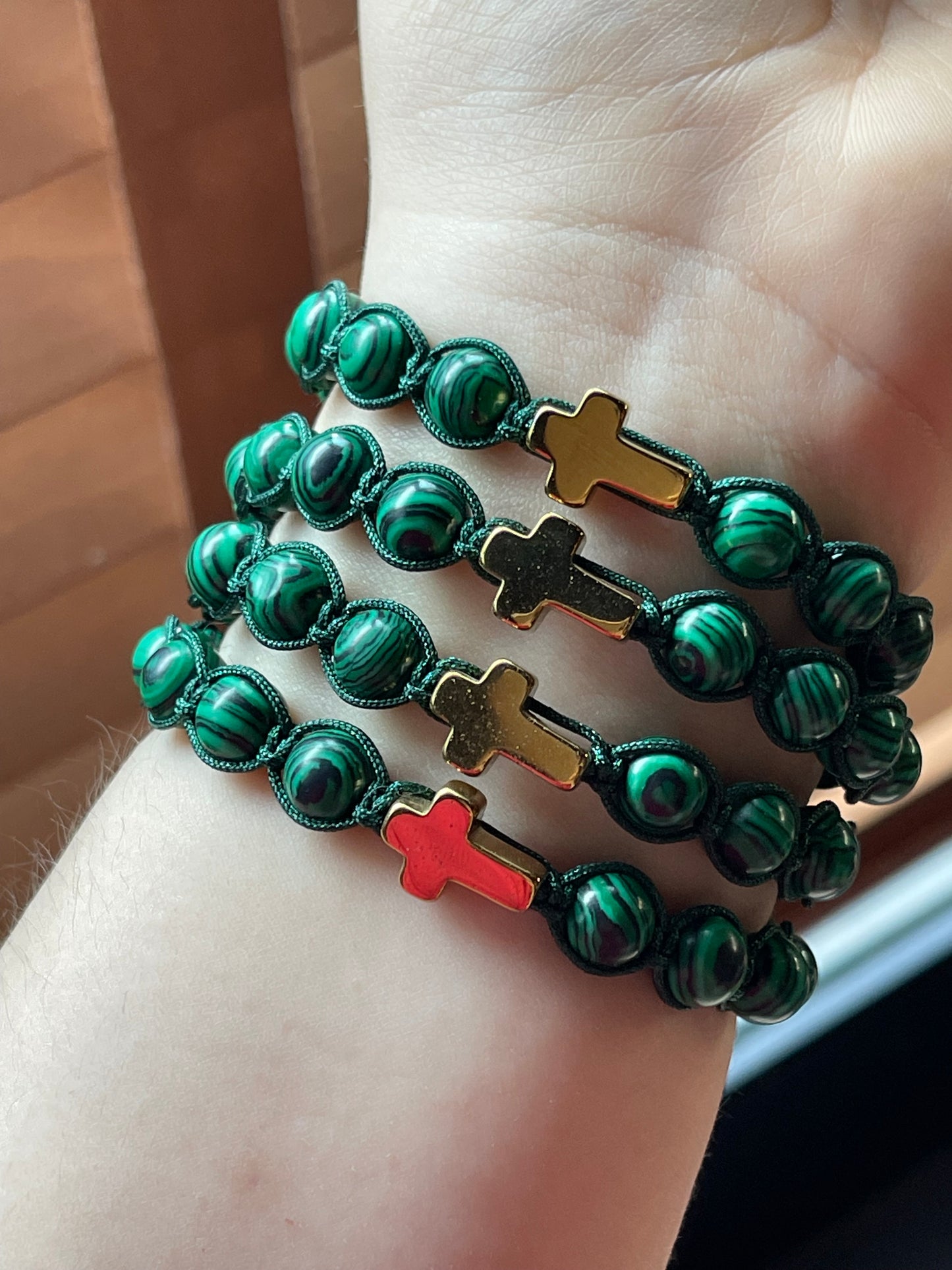 Pulseras tejidas de malaquita verde con dije de cruz en hematita dorada