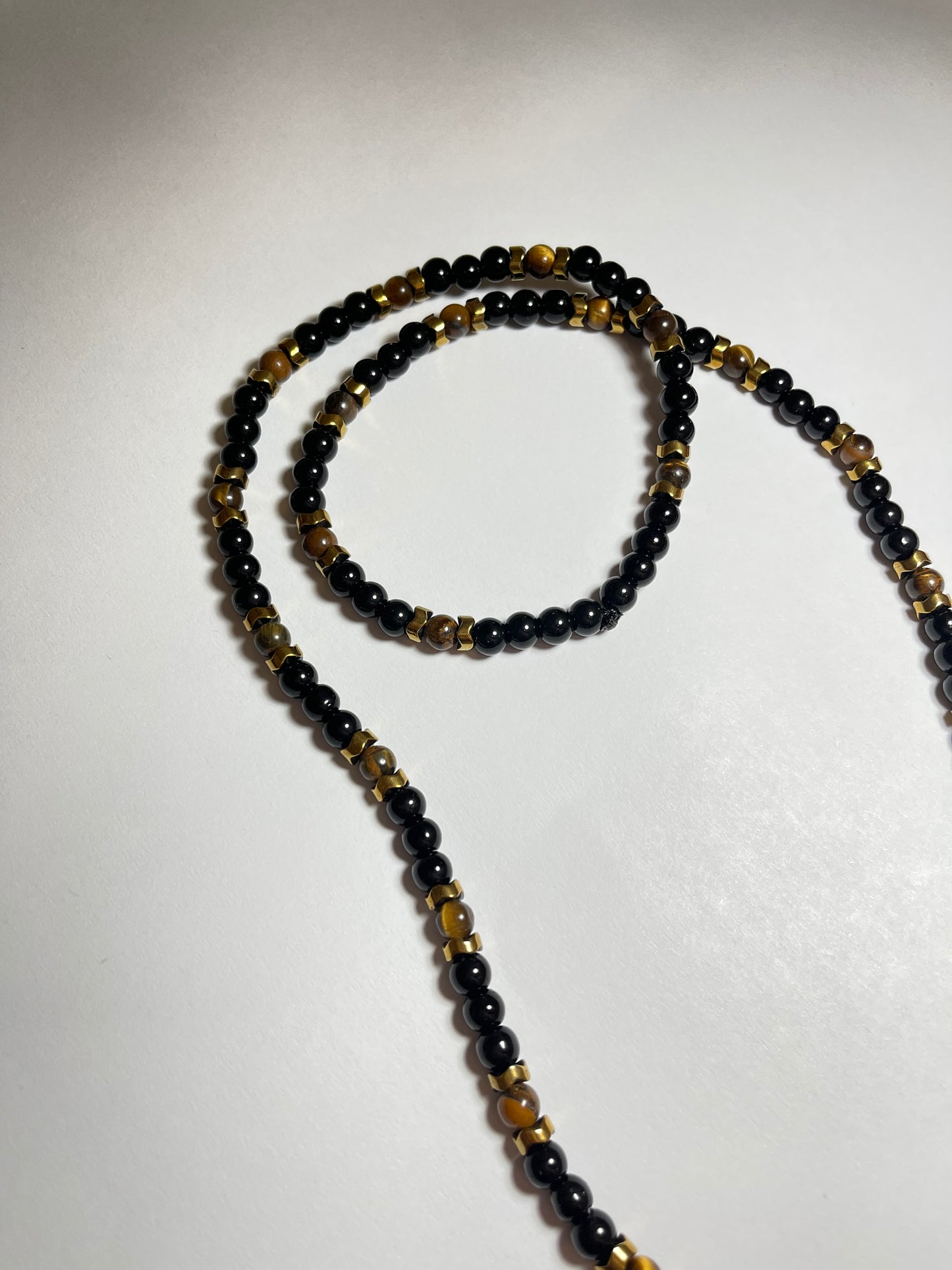Collar de ojo de tigre y hematita con dije de cruz en baño de oro 18k