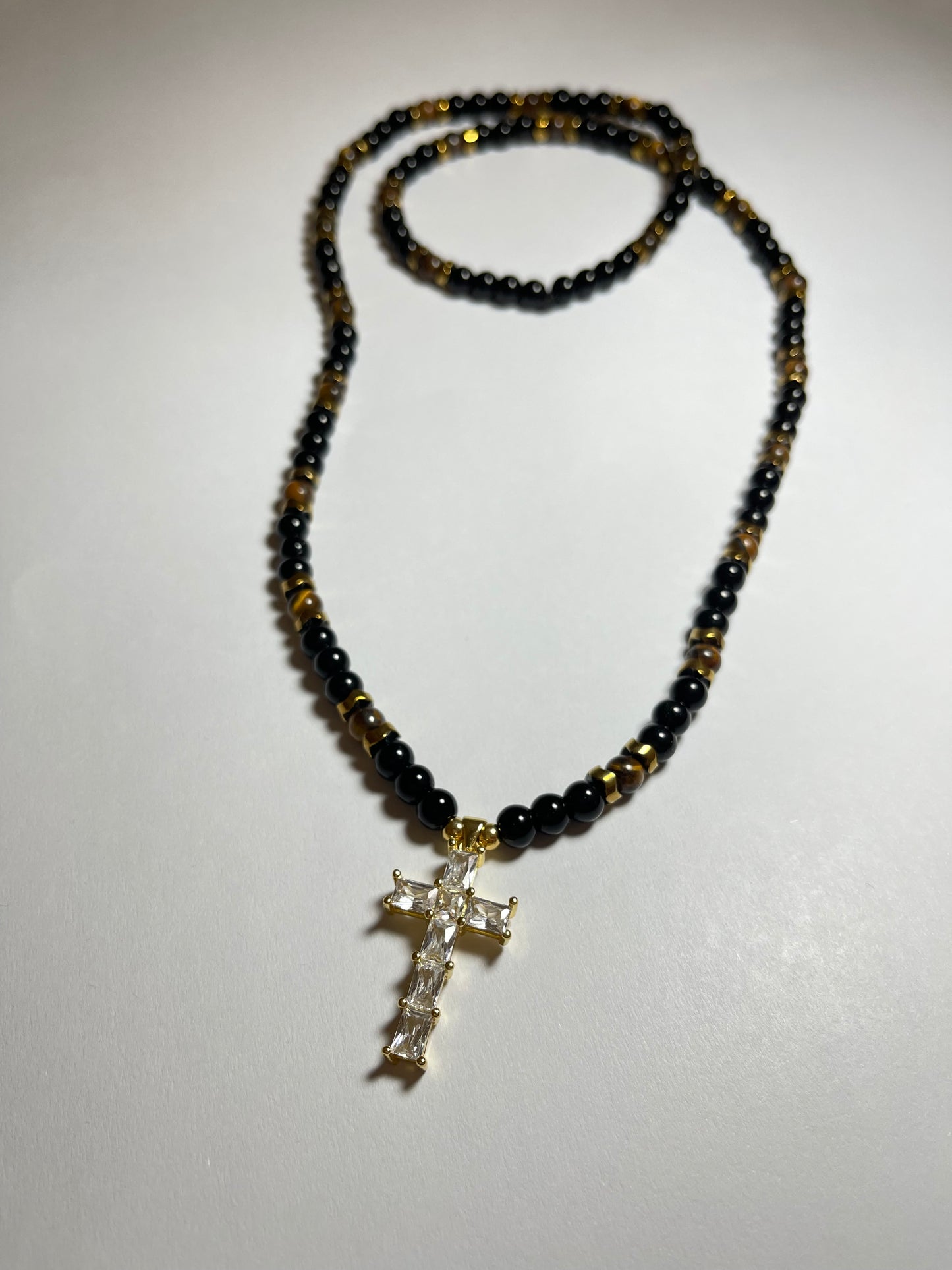 Collar de ojo de tigre y hematita con dije de cruz en baño de oro 18k