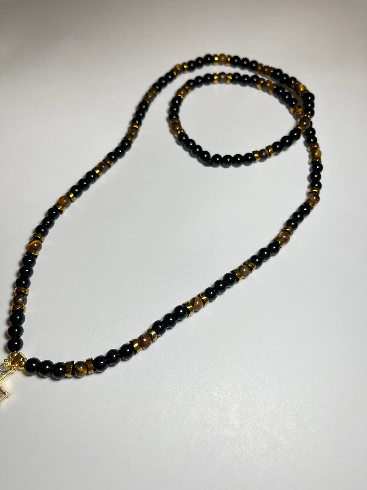 Collar de ojo de tigre y hematita con dije de cruz en baño de oro 18k