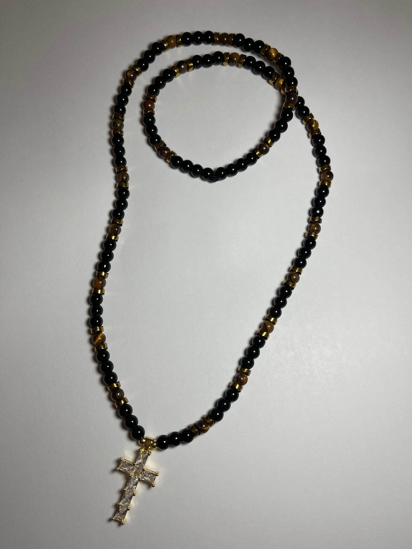 Collar de ojo de tigre y hematita con dije de cruz en baño de oro 18k